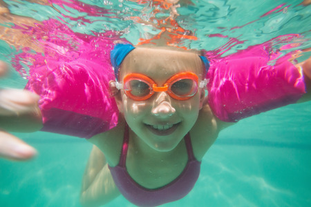 Cute kid posing underwater in pool at the leisure centerの写真素材