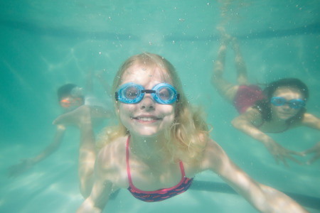 Cute kids posing underwater in pool at the leisure centerの写真素材