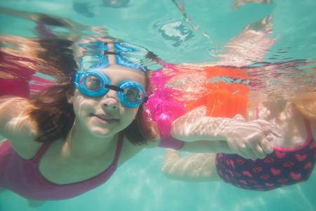 Cute kids posing underwater in pool at the leisure centerの写真素材