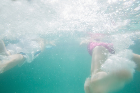 Cute kids swimming underwater in pool at the leisure centerの写真素材