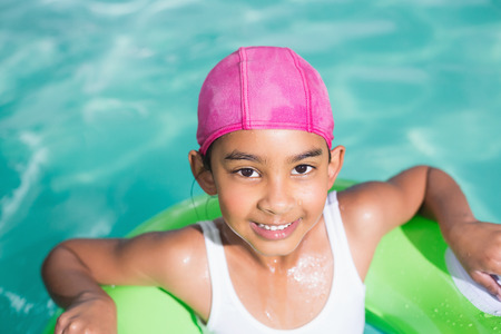 Cute little girl swimming in the pool at the leisure center