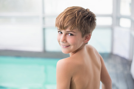 Cute little boy standing poolside at the leisure centerの写真素材