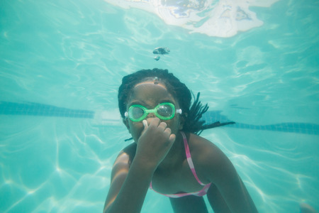 Cute kid posing underwater in pool at the leisure centerの写真素材