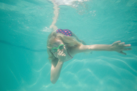 Cute kid posing underwater in pool at the leisure centerの写真素材