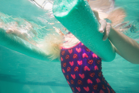 Cute kid posing underwater in pool at the leisure centerの写真素材