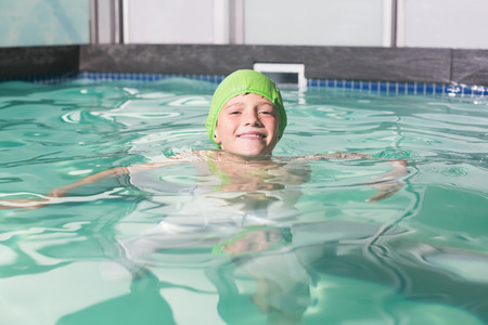Cute kid swimming in the pool at the leisure centerの写真素材