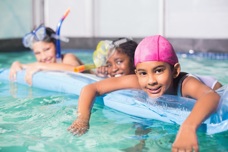 Cute little kids swimming in the pool at the leisure centerの写真素材
