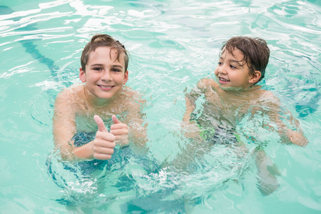 Cute little kids in the swimming pool at the leisure centerの写真素材
