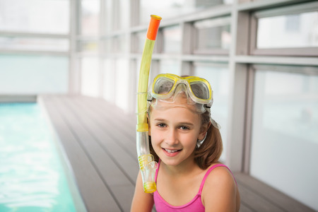 Cute little girl sitting poolside at the leisure centerの写真素材
