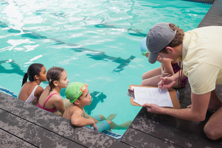 Cute swimming class listening to coach at the leisure centerの写真素材