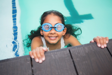 Cute little girl smiling in the pool at the leisure centerの写真素材