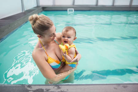 Pretty mother and baby at the swimming pool at the leisure centerの写真素材