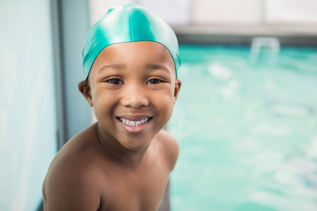 Cute little boy smiling at the pool at the leisure centerの写真素材