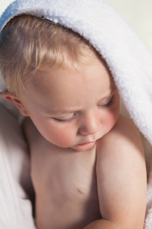 Cute baby wrapped in towel at the leisure centerの写真素材