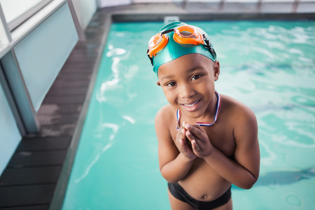 Cute little boy with his medal at the pool at the leisure centerの写真素材