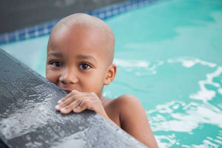 Cute little boy smiling in the pool at the leisure centerの写真素材