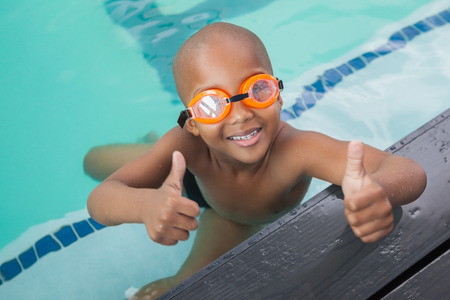 Cute little boy giving thumbs up at the pool at the leisure centerの写真素材