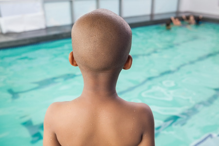 Cute little boy standing at the pool at the leisure centerの写真素材