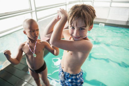 Little boys standing by the pool with medals at the leisure centerの写真素材