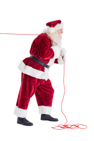 Santa pulls something with a rope on white backgroundの写真素材