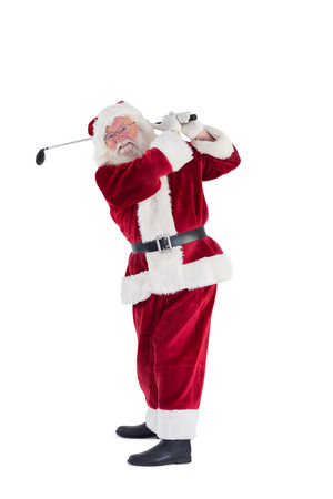 Santa Claus swings his golf club on white backgroundの写真素材