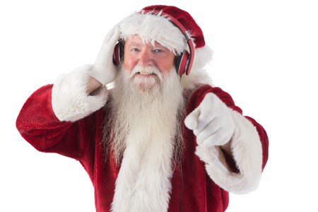 Santa is listening some music on white backgroundの写真素材