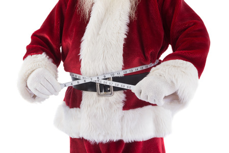 Santa Claus measures his belly on white backgroundの写真素材