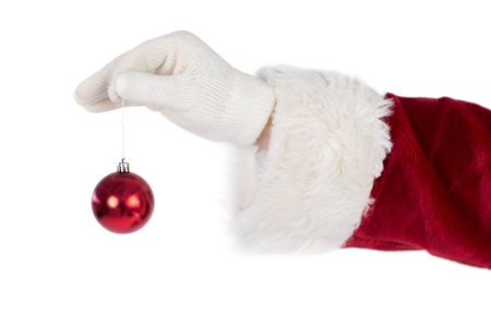 Santas hand is holding a Christmas bulb on white backgroundの写真素材