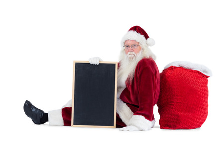 Santa sits leaned on his bag with a board on white backgroundの写真素材