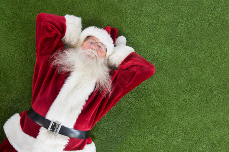 Santa lies, sleeps and has a nice dream on grassの写真素材