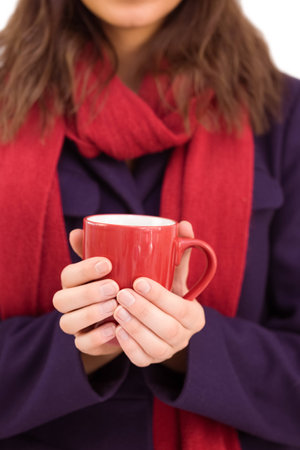 Woman in warm clothing holding mug on white backgroundの写真素材