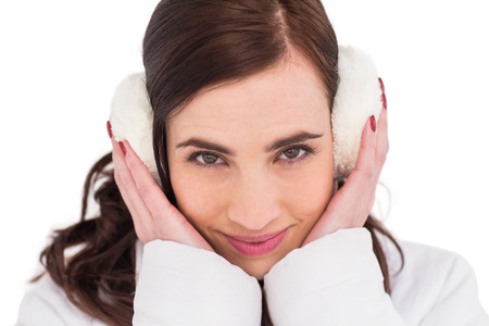 Pretty brunette with ear muffs on white backgroundの写真素材