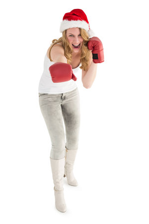 Festive blonde punching with boxing gloves on white backgroundの写真素材