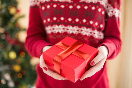 Close up of a woman offering a gift at home in the living room