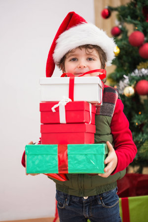 Cute festive little boy smiling at camera at home in the living roomの写真素材