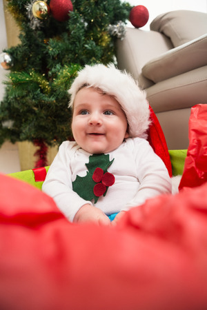 Cute baby boy in large christmas present at home in the living roomの写真素材