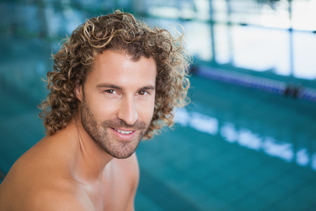 Close up portrait of a shirtless fit swimmer by the pool at leisure centerの写真素材