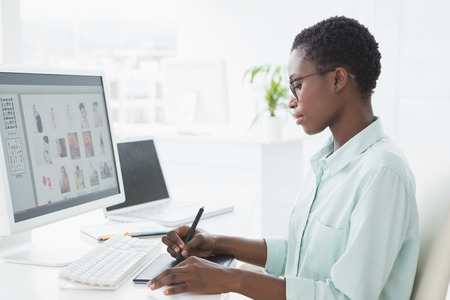 Photo editor working at her desk in creative officeの写真素材