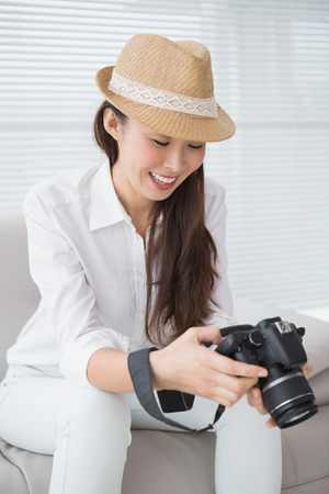 Photo editor looking at her camera in creative officeの写真素材