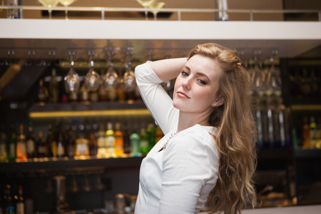 Pretty blonde girl in white dress posing hands in the hair at the nightclubの写真素材