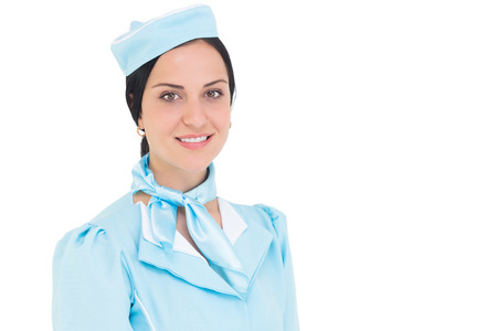 Pretty air hostess smiling at camera on white background