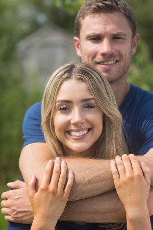 Cute couple smiling at camera at home in the gardenの写真素材