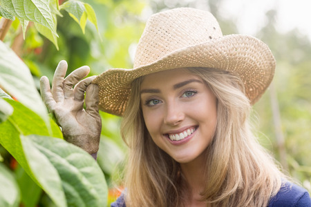 Pretty blonde smiling at camera at home in the gardenの写真素材