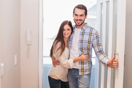 Cute couple walking through the door in their new homeの写真素材