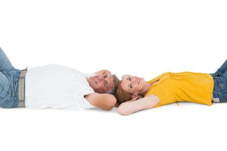 Casual couple lying on floor on white backgroundの写真素材