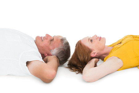 Casual couple lying on floor on white backgroundの写真素材