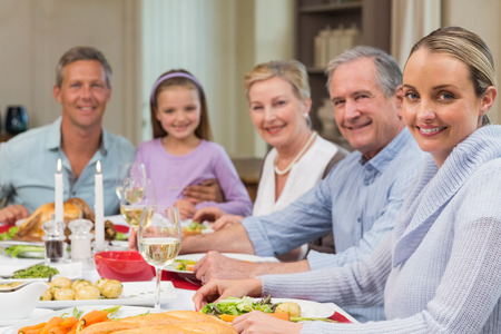 Happy extended family looking at camera at christmas time at home in the living roomの写真素材