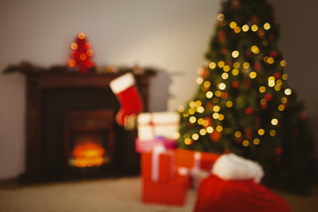Christmas tree with presents near the fireplace at home in the living room