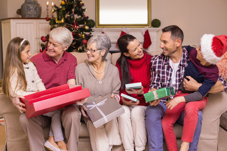 Festive family opening gifts at christmas at home in the living room