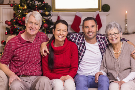 Portrait of a happy family sitting on sofa at home in the living room